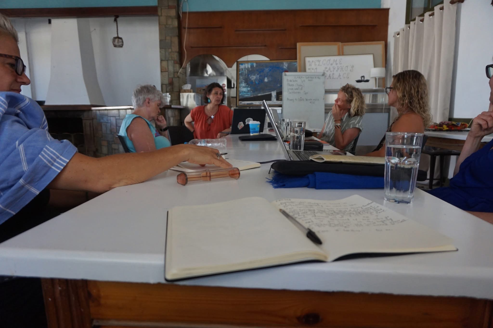 Writers gathered at a table for a session at Sappho's Palace